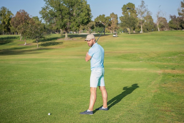 Golfeur en cap avec club de golf personnes mode de vie homme jouant au jeu sur l'activité estivale de l'herbe verte