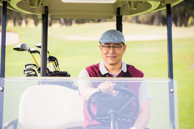 Golfeur conduisant un buggy de golf