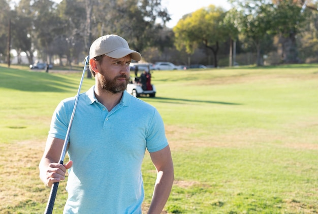 Golfeur homme en casquette avec club de golf sur l'herbe verte d'été, sport.