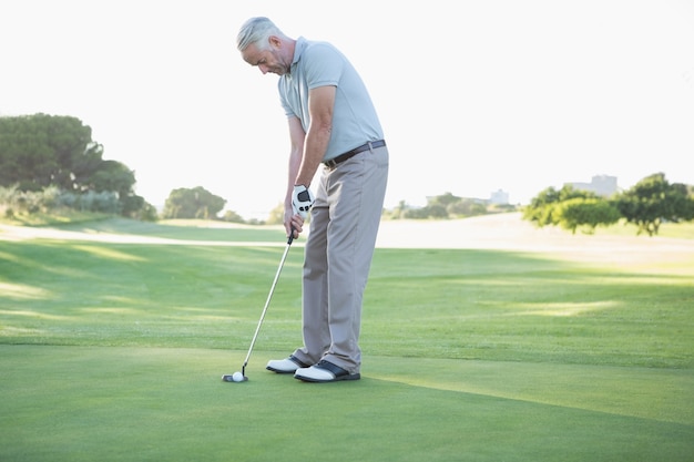 Golfeur mettant la balle sur le green