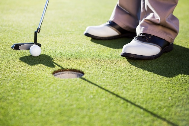 Golfeur mettant la balle sur le green