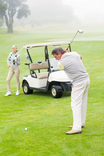 Golfeur sur le point de partir avec un partenaire derrière lui