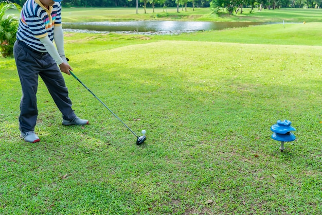 Golfeur se préparant pour une frappe par le conducteur de tee dans un parcours de golf.