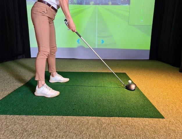 Golfeuse professionnelle jouant au golf à l'intérieur sur un simulateur de golf en gros plan