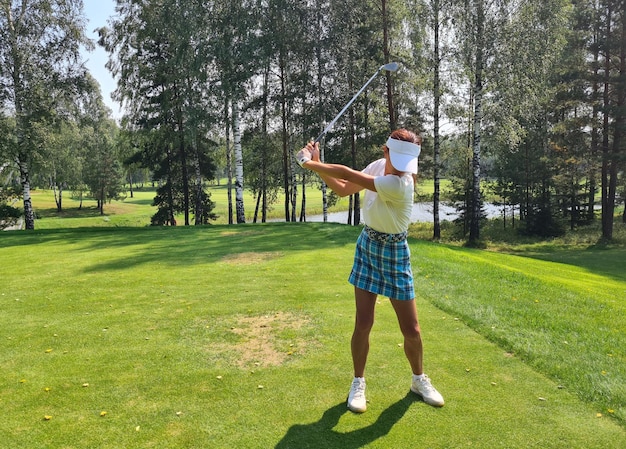 Une golfeuse professionnelle en vêtements de sport joue au golf lors d'un tournoi d'entraînement de golf sur le parcours