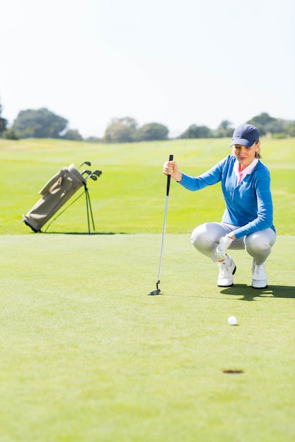 Golfeuse regardant sa balle sur le green