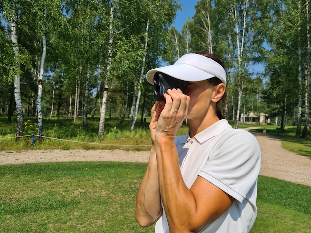 Une golfeuse regarde le télémètre pour mesurer le concept de distance