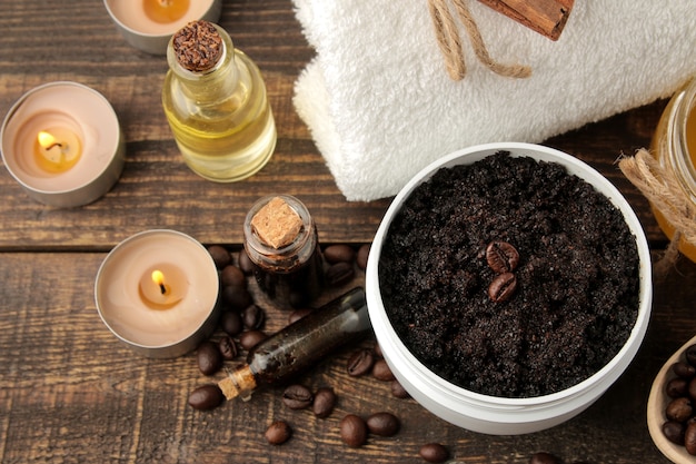 Gommage au café maison dans un pot blanc pour le visage et le corps et divers ingrédients pour faire un gommage.