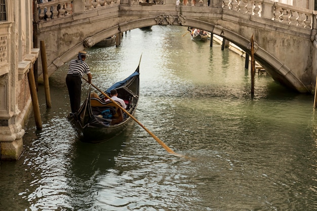 Gondole dans un canal de Venise passant sous un pont