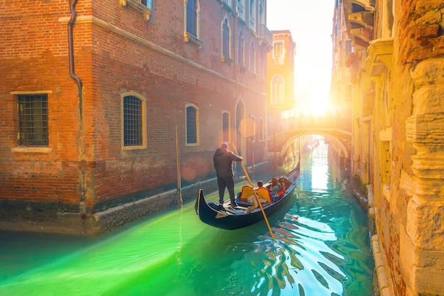 Gondole et gondolier du canal de Venise avec des touristes voyageant par eau dans la ville