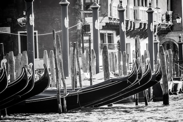 Photo des gondoles amarrées dans le grand canal contre un bâtiment par une journée ensoleillée