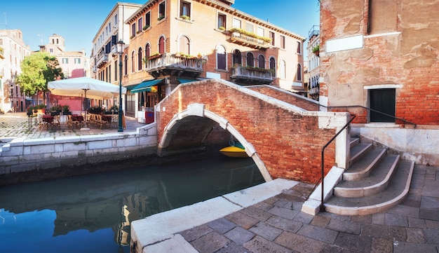 Gondoles traditionnelles sur canal étroit entre les maisons historiques colorées à Venise, Italie