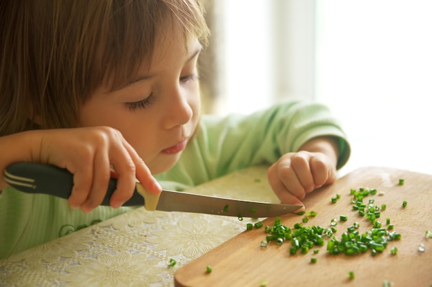 Gosse coupant l'oignon vert