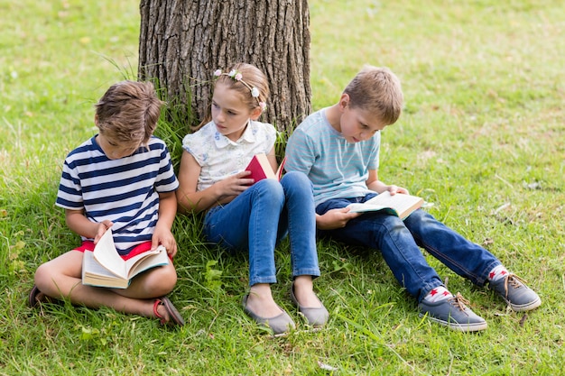 Gosses, lecture livres, dans parc