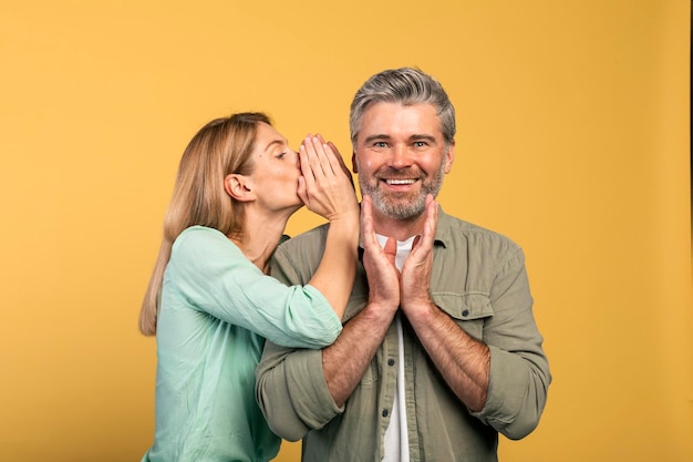 Gossip partager des conseils Femme chuchotant à son mari sur l'oreille heureux homme surpris écoute femme