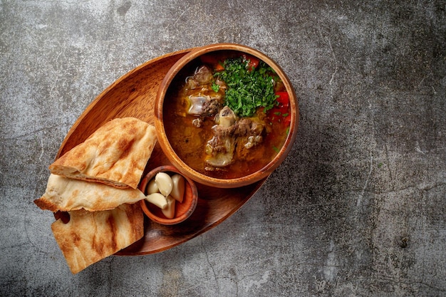 Goulage de boeuf à l'ail et pain pita sur une table en pierre grise, Flatlay