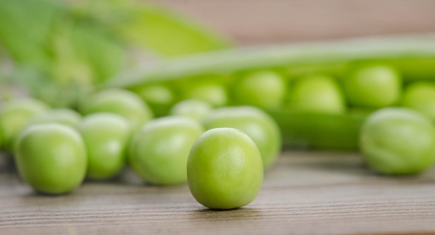 Photo gousse de pois verts sur la table en bois