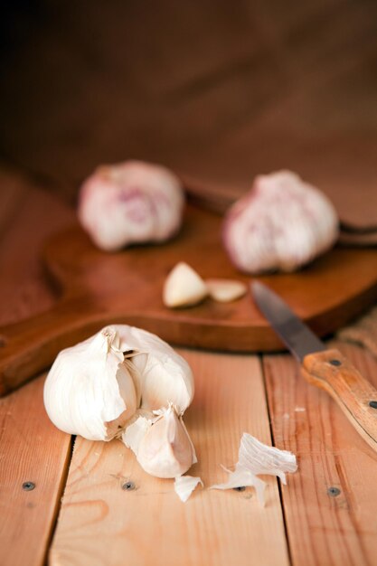 Gousses d'ail et bulbe d'ail sur une table en bois blanc. aliments biologiques de style rustique - ail sur table en bois