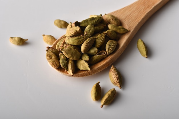 Gousses de cardamome verte sur une surface blanche