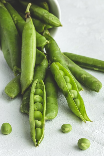 Gousses de pois verts crus sur fond clair