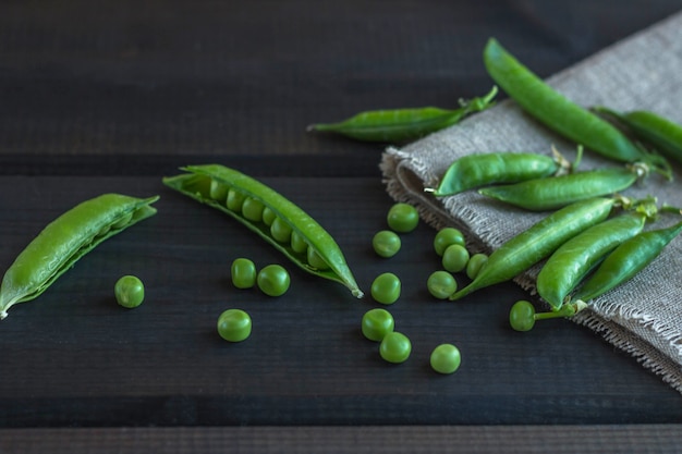 Gousses de pois verts et de pois sur une surface en bois sombre