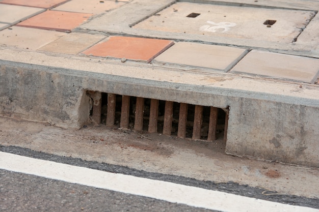 Égout d'égout le long de la route en ville