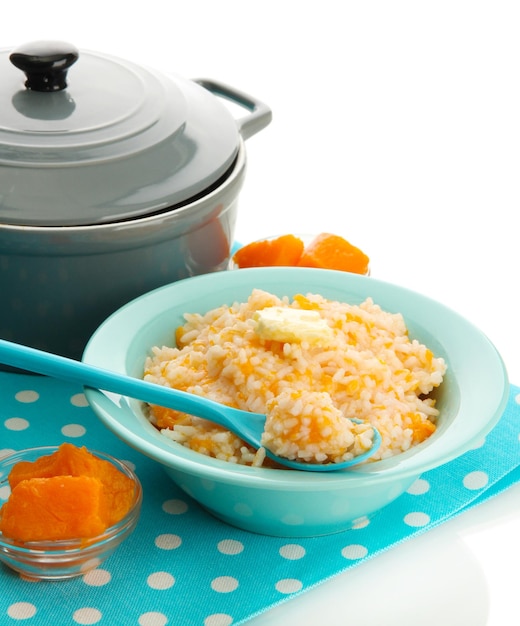 Goûtez la bouillie de riz à la citrouille dans un bol bleu isolé sur blanc