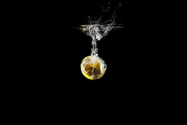 Goutte de citron dans l'eau noire