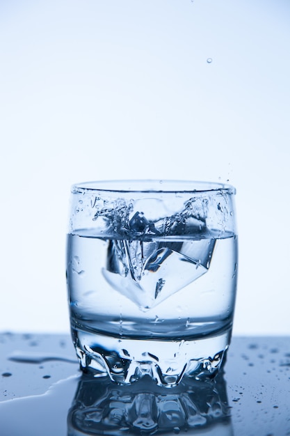 Une goutte d'eau minérale fraîche dans un verre de glaçon, un bon dégradé.