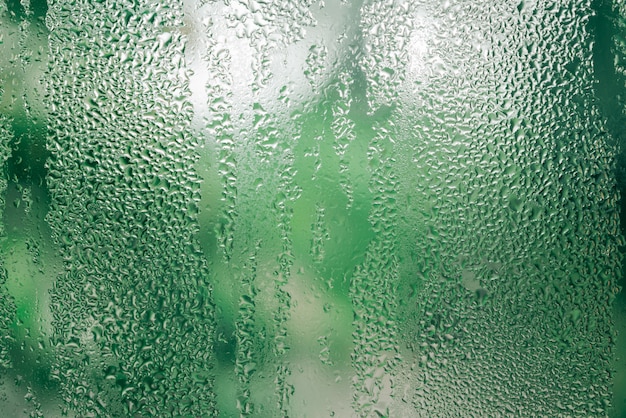 Goutte de pluie sur la fenêtre de verre vert Bokeh environnement de fond conceptuel, pluie d'été