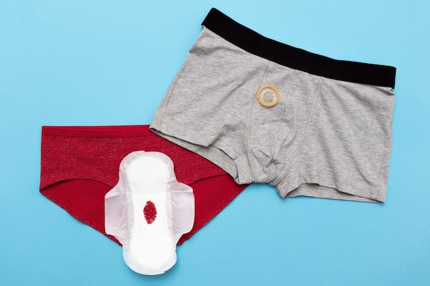 Goutte rouge de perles sur un pantalon sur fond bleu Période menstruelle