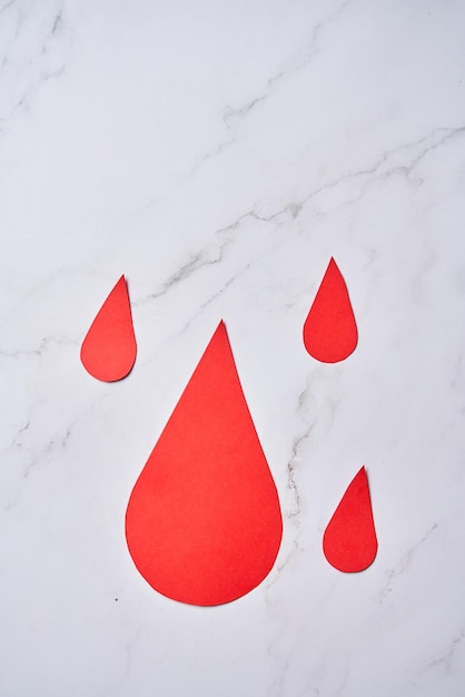 Goutte de sang papier découpé transfusion sanguine journée mondiale du donneur de sang croix rouge pour donner le concept de la journée mondiale de l'hémophilie