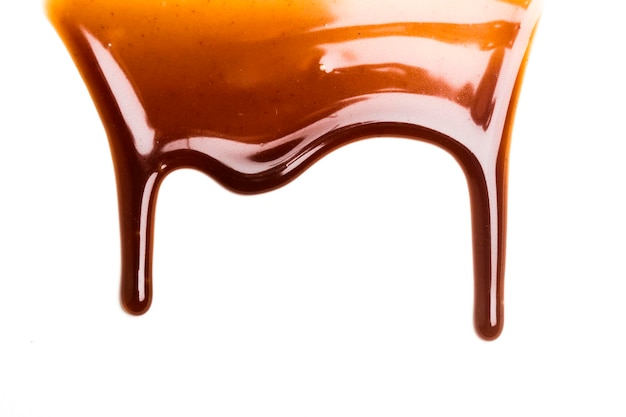 Goutte de sauce au caramel au chocolat sur un fond blanc uni