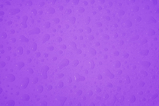 Gouttelettes d'eau de couleur violette sur la table