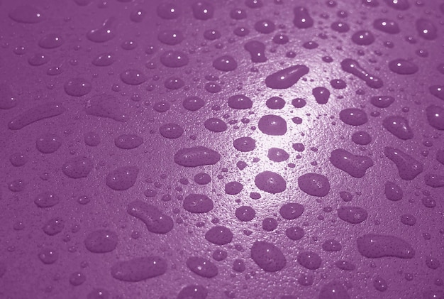 Gouttelettes d'eau sur la table de jardin de couleur violet foncé après la pluie