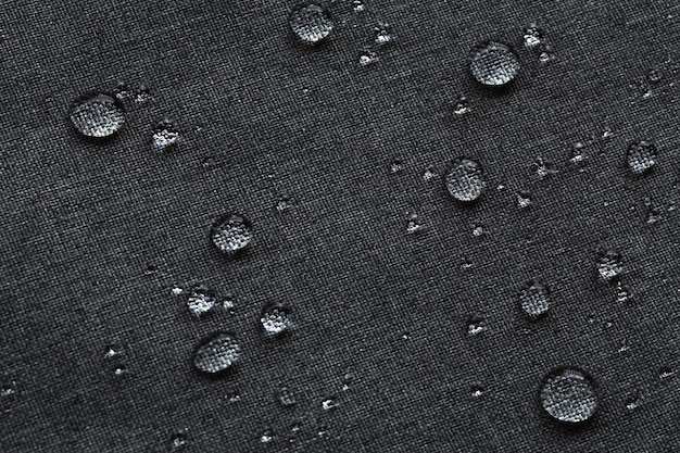 Gouttelettes imperméables sur tissu Toile noire Texture polyester synthétique pour fond Toile de fond textile en polyester noir pour la conception d'art intérieur ou ajouter un message texte