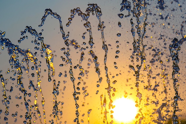 Gouttes de chute d'eau fontaine au soleil couchant