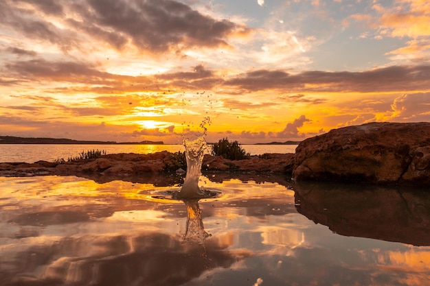 Gouttes d'eau après le jet d'une pierre au coucher du soleil à San Antonio Abad Ibiza Island