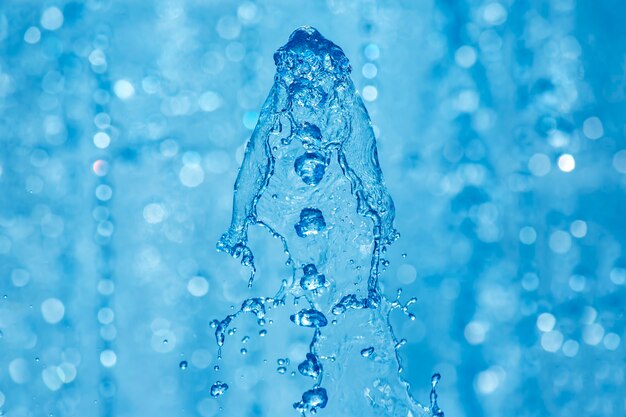 Gouttes d'eau bleue de la fontaine dans le ciel