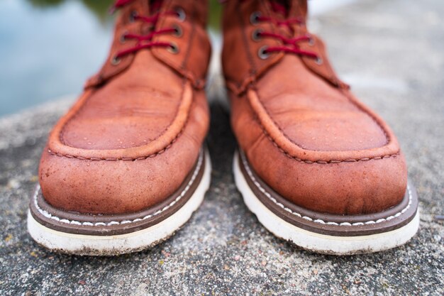 Gouttes d'eau sur les bottes de travail en cuir rouge