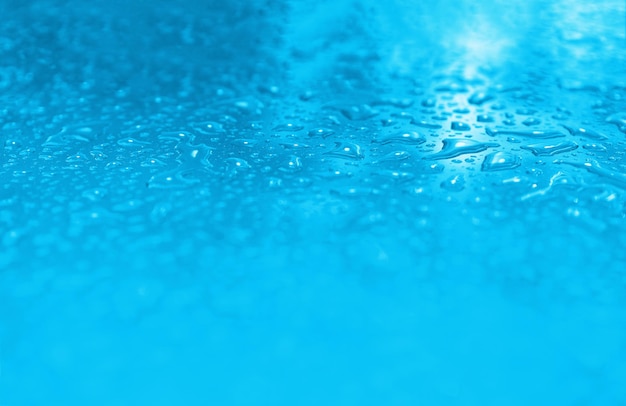 Gouttes d'eau cyan après l'arrière-plan flou de pluie