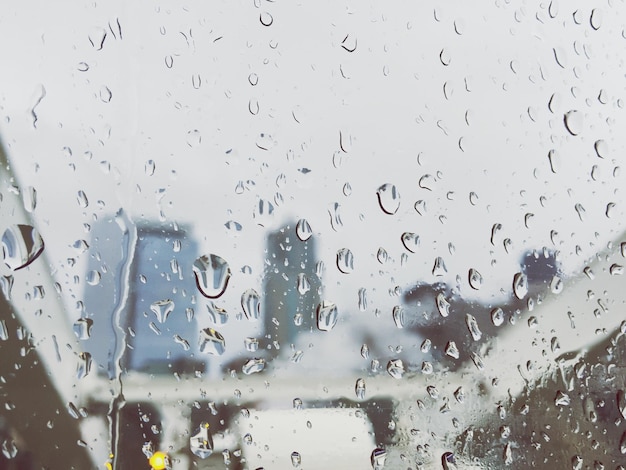 Des gouttes d'eau sur une fenêtre de verre contre le ciel