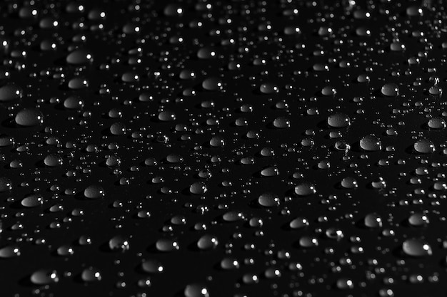 Gouttes d'eau sur fond noir. texture. rosée à la surface. mouillage. gouttes après la pluie ou le brouillard.