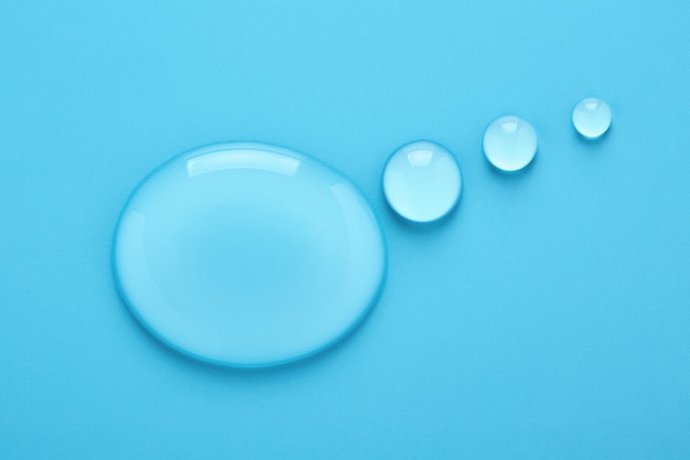 Gouttes d'eau en forme de bulle de pensée sur fond bleu.