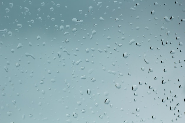 Gouttes d'eau sur les gouttes de pluie de voiture sur la fenêtre transparente