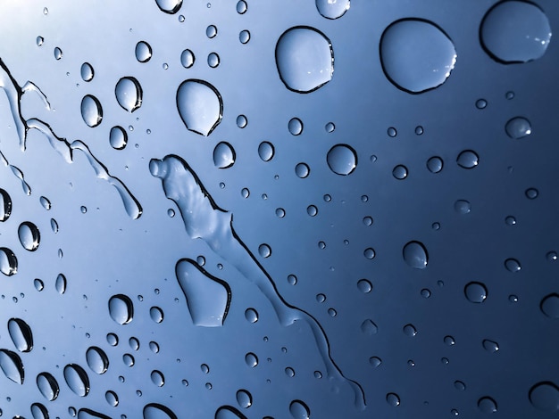 Gouttes d'eau en mouvement à travers la fenêtre après la pluie