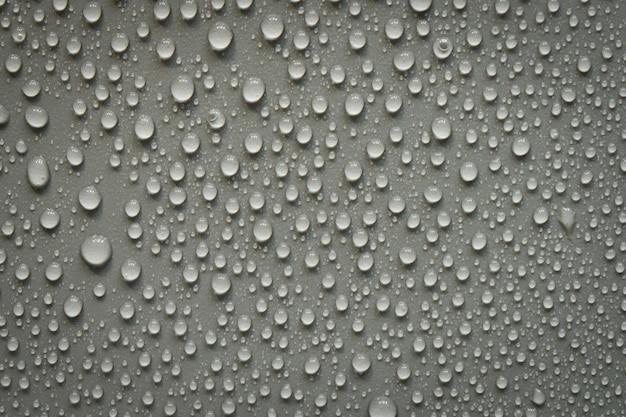 Gouttes d'eau sur une surface en plastique noir Sur fond noir Vue de dessus