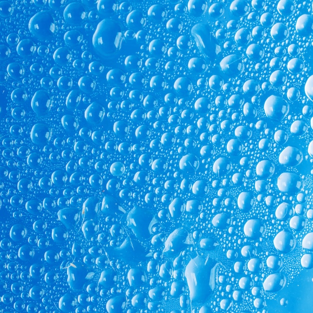 Gouttes d'eau sur verre bleu