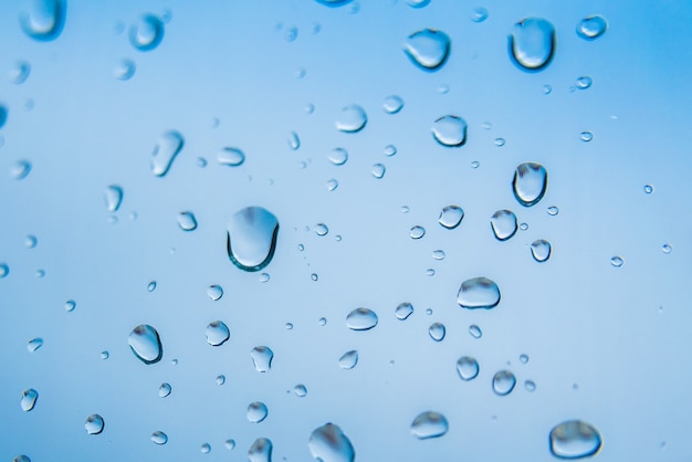 Gouttes d'eau sur le verre de la fenêtre ton bleu