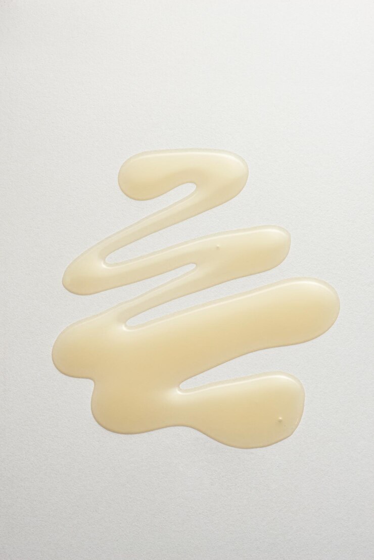 Photo gouttes d'huile jaune sur fond blanc macro